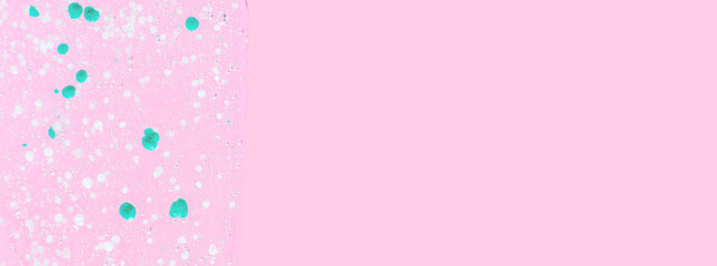Smeared transparent gel with blue granules. On a pink background.