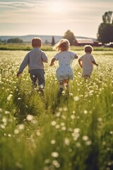 Back view of young children running over a blossoming meadow on a sunny summer day