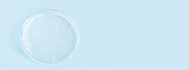 Facial Detergent in a Petri dish on a blue background.