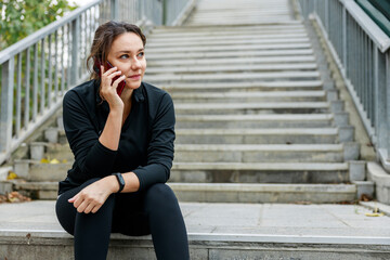 Fototapeta premium Young sporty woman talking on mobile phone