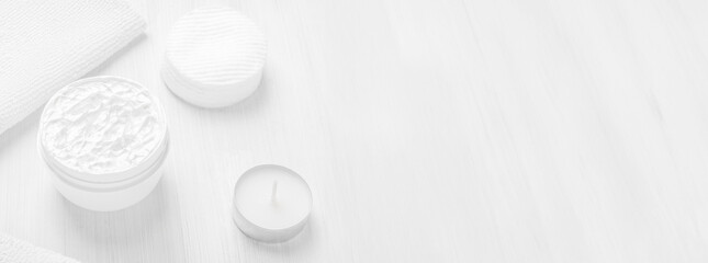 Pure white moisturizer in a white jar.  Cotton sponges. White towel.