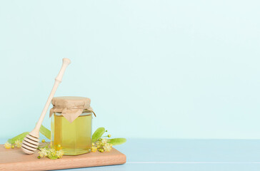 Linden honey with leaves and flowers on table