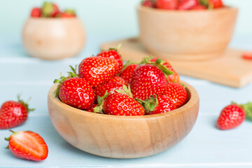 Fresh strawberries in bowl on wooden table