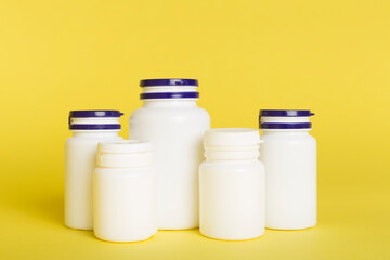 Plastic bottles for vitamins on color background