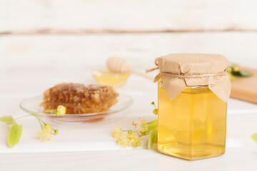 Linden honey with leaves and flowers on table
