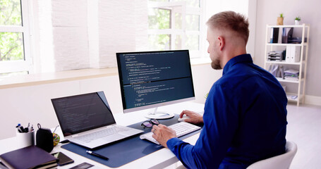 Computer Programmer Writing Program Code On Computer