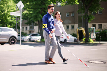 Young Woman Helping Blind Man With White Stick