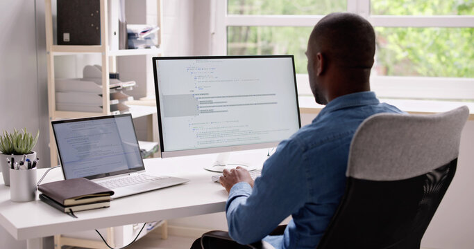 Computer Programmer Writing Program Code On Computer