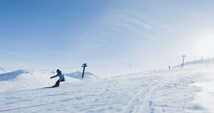 Experienced male skier skiing on slopes on a ski center. Recorded at 120 fps.