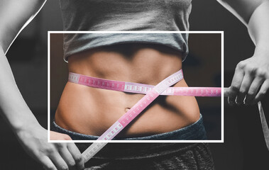 Slim girl bodybuilder centimeter measuring her waist in a gym. Sports concept, fat burning and a...