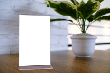 Mock up Menu frame standing on wood table in Bar restaurant cafe. space for text