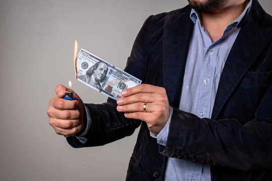 Hombre quemando dinero en concepto de p&eacute;rdida