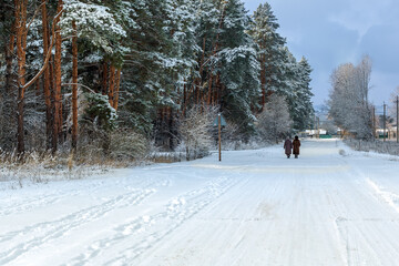 Forest and women.Winter landscape and two women for a walk.Snowy road in the countryside from Ukraine in winter.