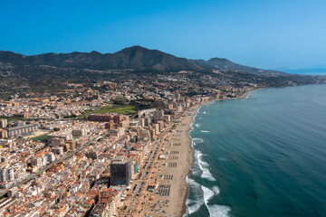 Aerial drone photo of the beautiful beach front of the coastal town of Fuengirola in Malaga Spain Costa Del Sol, showing the sandy beach, hotels and apartments with the mountains in the background