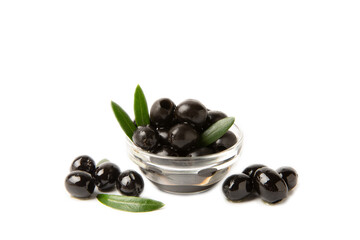 Black olives isolated on white background. Olives in a bowl. Olive tree leaves. Vegan. Ingredient...