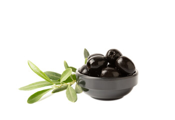 Black olives isolated on white background. Olives in a bowl. Olive tree leaves. Vegan. Ingredient for salad or pizza.