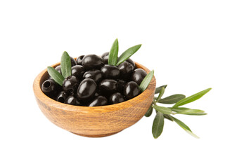 Black olives isolated on white background. Olives in a bowl. Olive tree leaves. Vegan. Ingredient for salad or pizza.