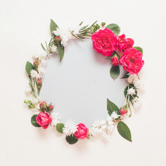 Summer wreath made of colorful flowers and leaves. Natural round frame layout with paper card. Flat lay.