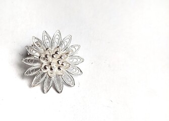 Filigree silver brooch with flower motif isolated on white background.