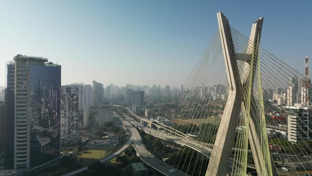 View of the Pinheiros river with modern buildings beside it and the famous Octavio Frias de Oliveira bridge in the city of S&atilde;o Paulo.