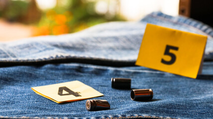 Pistol bullet shells on blur blue jeans and number displays in background, concept for criminal and...
