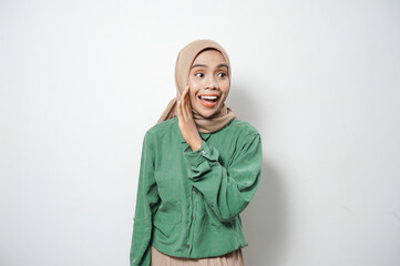 Cheerful young beautiful Asian Muslim woman shouting loud at copy space