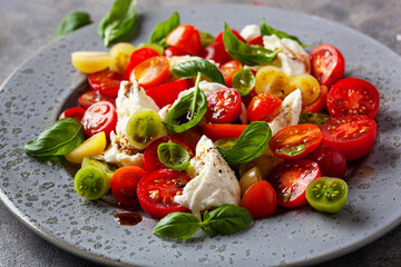 healthy colorful tomato mozzarella basil salad with balsamic vinegar dressing
