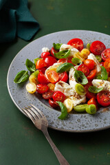 healthy colorful tomato mozzarella basil salad with balsamic vinegar dressing