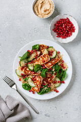 healthy halloumi cheese and couscous salad with cucumber spinach pomegranate hummus