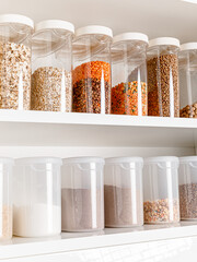 Stocked kitchen pantry with food. The organization and storage in a kitchen in plastic containers....