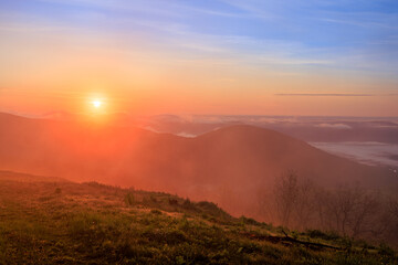 Misty sunrise with sun glowing through fog in Blue Ridge Mountains with Fog in the valley