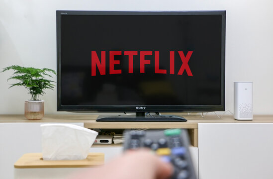Watching Netflix On Television Screen, Hand Holding Remote Control In Foreground Out Of Focus, First Person Perspective, Depicting Home Life, Selective Focus