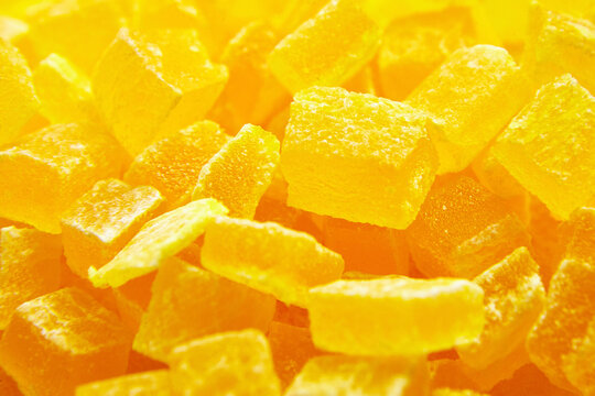 Diced mango dried fruits texture background. Dehydrated mango chips dices, sweet food closeup