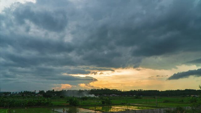 Time lapse cloudy sky landscape over rice fields in the afternoon. Video of natural scenery clouds drifting away.
