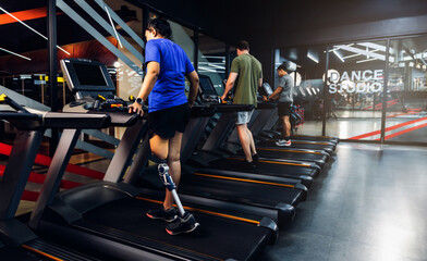 Sports woman with artificial leg running on treadmill at gym. Woman with prosthetic leg using...