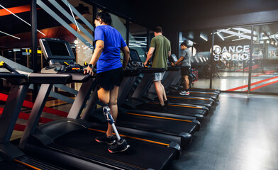 Sports woman with artificial leg running on treadmill at gym. Woman with prosthetic leg using walking on treadmill while working out in gym.