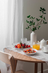 Cozy breakfast served - porridge oatmeal with seasonal fruits and berries, orange juice, tea on a...