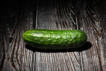 single cucumber on wood background