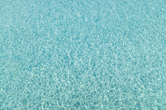 Tropical beach water background. Idyllic texture or crystal clear water surface, transparent sea ocean ecology nature concept. Sunlight, bright water pattern wallpaper