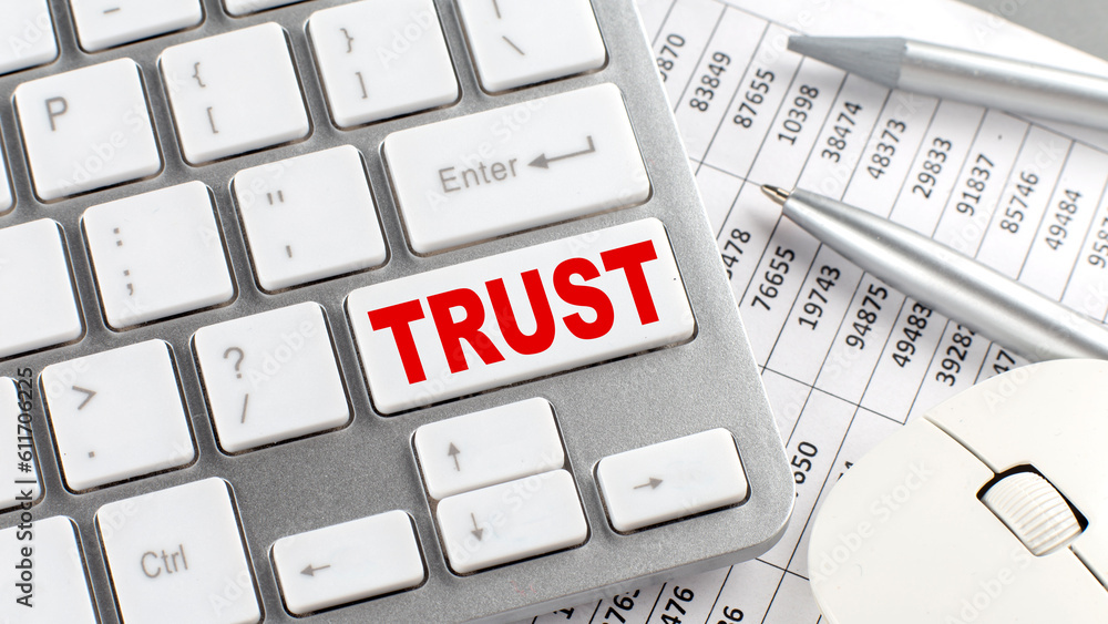 Poster trust text on a keyboard wirh chart and pencil