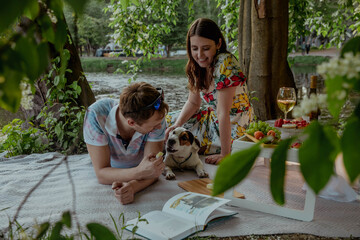 Romantic picnic for couple and dog at sunset in summer