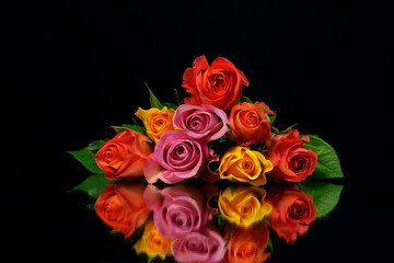 Beautiful Bouquet of roses and flowers, used for love and passion and wedding bells. Shot on a reflective surface in a studio with a dark black background.Beautiful Vintage, stacked on top