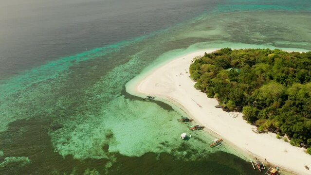 Small tropical island on an atoll with beautiful sandy beach surrounded by coral reef from above. Tropical island and coral reef. Summer and travel vacation concept, Camiguin, Philippines, Mindanao