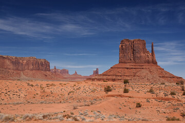 Amazing red rock formations in the Monument Valley, Navajo Tribal Park, Utah, USA. Dry landscape and dramatic clouds.