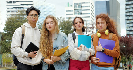Group of diverse teenage students with folders looking seriously at camera. High school, university...