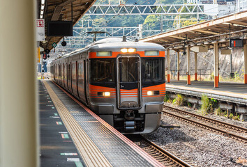 Fototapeta na wymiar Local train arrive to railway station platform in Japan.
