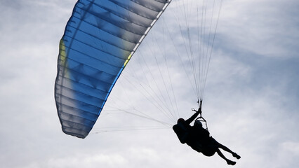 Closeup of two paragliders gliding through the sky