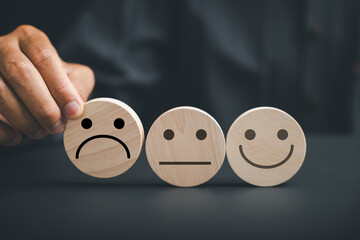 Negative customer experience concept. Holding frown icon on wooden circle, customer expresses...