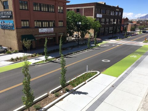 Ogden, Utah, USA - 2 July 2019: Looking down at new bike lane on Grant Ave in Ogden UT.  New green protected bike lanes on an empty wide street in Ogden Utah.