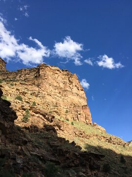 Beautiful mountains with deep blue skies and a few puffy clouds up 9 Mile Canyon, Helper, Utah. warm golden hour light illuminates a mountain cliff in the late afternoon, Nine Mile Canyon, Utah.